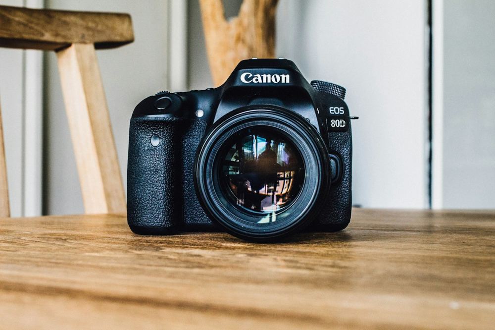 Ahşap bir yüzeyde duran fotoğraf makinesi