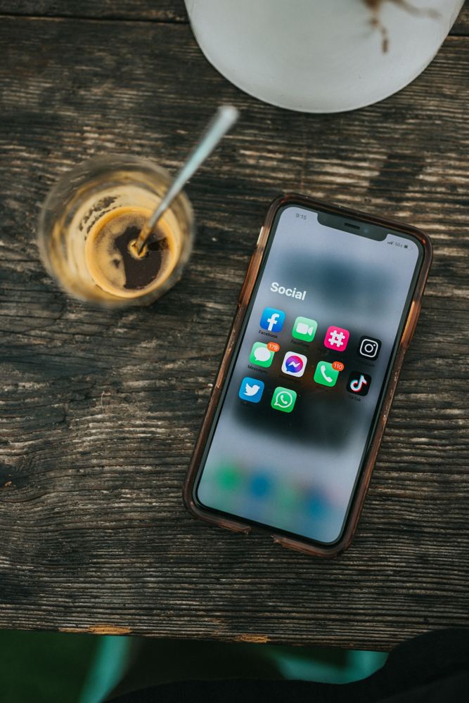 Ahşap masada sosyal medya uygulamaları açık bir akıllı telefon